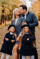 A large family walks in the park in the fall. Happy people in the autumn park photo