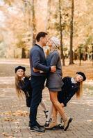 A large family walks in the park in the fall. Happy people in the autumn park photo