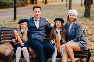 A large family is sitting on a bench in an autumn park. Happy people in the autumn park photo