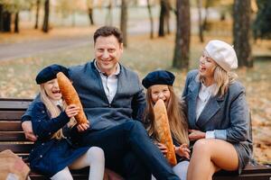 A large family is sitting on a bench in an autumn park. Happy people in the autumn park photo