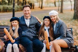 A large family is sitting on a bench in an autumn park. Happy people in the autumn park photo