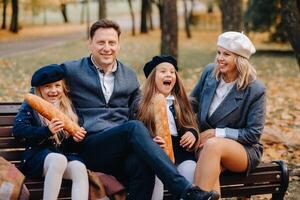 A large family is sitting on a bench in an autumn park. Happy people in the autumn park photo