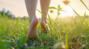 A person walking through a field with their bare feet photo