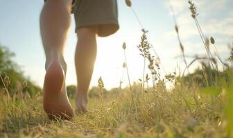 A person walking through a field with their bare feet photo