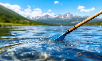 A paddle is in the water with mountains in the background photo