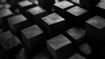 Close up of black cubes arranged in a pattern. Concept of order and structure, with the black cubes forming a grid-like pattern. The monochromatic color scheme adds to the overall minimalist photo