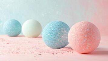 Group of colorful eggs with blue and pink sprinkles on them. The eggs are arranged in a row on a pink surface photo