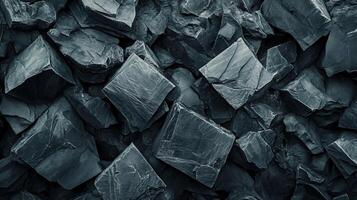 Close up of a pile of rocks with a dark grey color. The rocks are of various sizes and shapes, and they appear to be piled on top of each other. Concept of ruggedness and strength photo