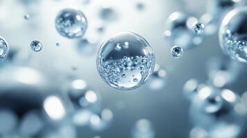 Close up of a bunch of water droplets with a clear blue background. The droplets are all different sizes and are scattered throughout the image photo