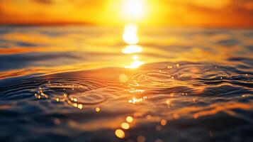 The sun is setting over the ocean, casting a warm glow on the water. The water is calm and still, with ripples forming around the sun's reflection. The scene is serene and peaceful photo