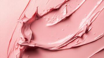Pink blob of makeup is smeared across a white background. The makeup is thick and creamy, with a slightly glossy texture. Concept of playfulness and creativity photo