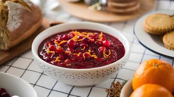 A bowl of cranberry sauce with oranges and bread photo