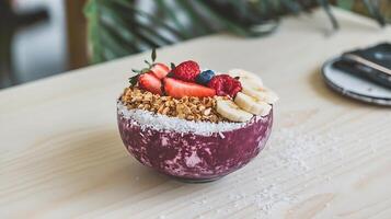 A bowl of fruit and granola topped with berries photo