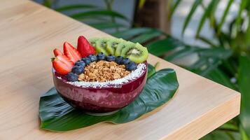 A bowl of fruit and granola on a wooden table photo