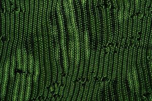 A close-up of green knitted fabric texture, detailed pattern, and vibrant color, suitable for backgrounds. photo