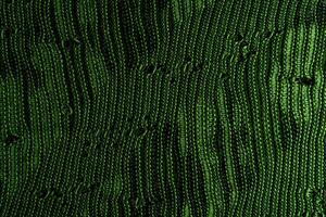 A close-up of green knitted fabric texture, detailed pattern, and vibrant color, suitable for backgrounds. photo