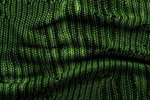 A close-up of green knitted fabric texture, detailed pattern, and vibrant color, suitable for backgrounds. photo