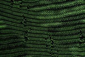 A close-up of green knitted fabric texture, detailed pattern, and vibrant color, suitable for backgrounds. photo