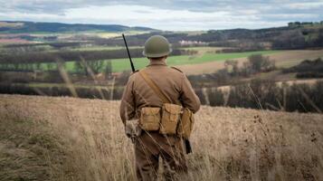 A soldier in a field with a rifle and a hat photo