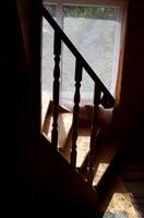 Fragment of a wooden staircase against the background of a window with tulle photo