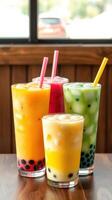 Colorful bubble tea drinks served in tall glasses at a cafe with a warm ambiance during a sunny afternoon photo