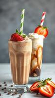 Refreshing chocolate and coffee milkshakes topped with whipped cream and strawberries in a cozy setting photo