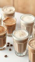 Variety of iced coffee drinks displayed in glasses on a table with coffee beans scattered nearby photo