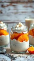 Delicious dessert featuring creamy yogurt layered with fresh peaches and topped with whipped cream served in glass jars photo