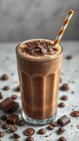 Delicious chocolate smoothie topped with chocolate shavings and a striped straw on a textured surface photo
