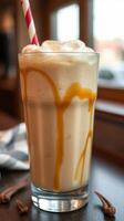 Delicious caramel milkshake served in a tall glass with whipped cream and a striped straw on a cozy cafe table photo