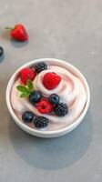 Creamy yogurt topped with fresh berries served in a bowl photo