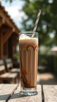 Creamy iced coffee with chocolate swirl served outdoors on a sunny day photo