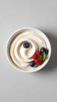 Delicious creamy yogurt served with fresh blueberries and strawberries topped with a mint sprig photo