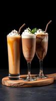 Three delicious creamy coffee drinks served on a wooden board in a dark setting photo