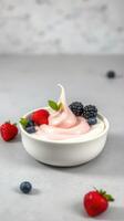 Delicious yogurt topped with fresh berries in a white bowl on a light surface photo