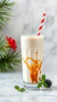 Creamy milkshake with caramel drizzle and mint leaves on marble countertop photo
