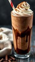 Delicious chocolate shake topped with whipped cream served in a tall glass with a straw photo