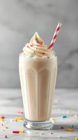 Delicious creamy milkshake topped with whipped cream and colorful sprinkles served in a tall glass photo