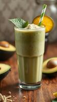 Refreshing green smoothie made with avocado and garnished with mint and a slice of mango photo