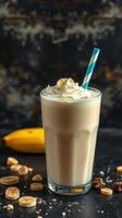 Delicious banana smoothie topped with whipped cream and nuts served in a tall glass against a dark background photo