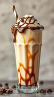 Creamy caramel milkshake topped with whipped cream and chocolate drizzle in a glass photo