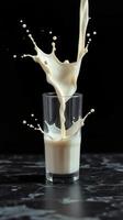 Milk splashes dramatically from a glass on a dark background in a creative display of motion and texture photo