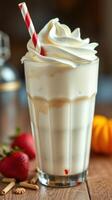Creamy milkshake topped with whipped cream and garnished with strawberries and pumpkin on rustic table photo