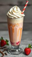 Delicious milkshake topped with whipped cream and a straw garnished with fresh strawberries photo