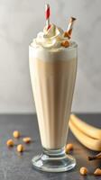 Delicious creamy banana milkshake topped with whipped cream and crunchy toppings photo