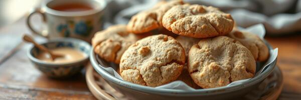 Cookies on a plate paired with tea and a small bowl of spread in a cozy kitchen setting photo
