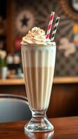 Creamy milkshake topped with whipped cream and colorful sprinkles served in a vintage glass at a cozy diner photo