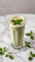 Refreshing mint smoothie served in a tall glass with fresh mint leaves on a marble table photo