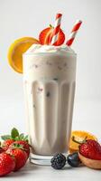 Refreshing fruit smoothie served in a tall glass with strawberries, blackberries, and citrus slices on a sunny day photo