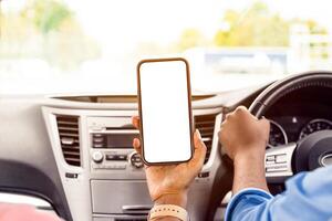 Back rear over the shoulder view of happy black female passenger holding smartphone with white blank screen, mock up, sitting on front seat in car. Couple using mobile app for navigation, copy space photo